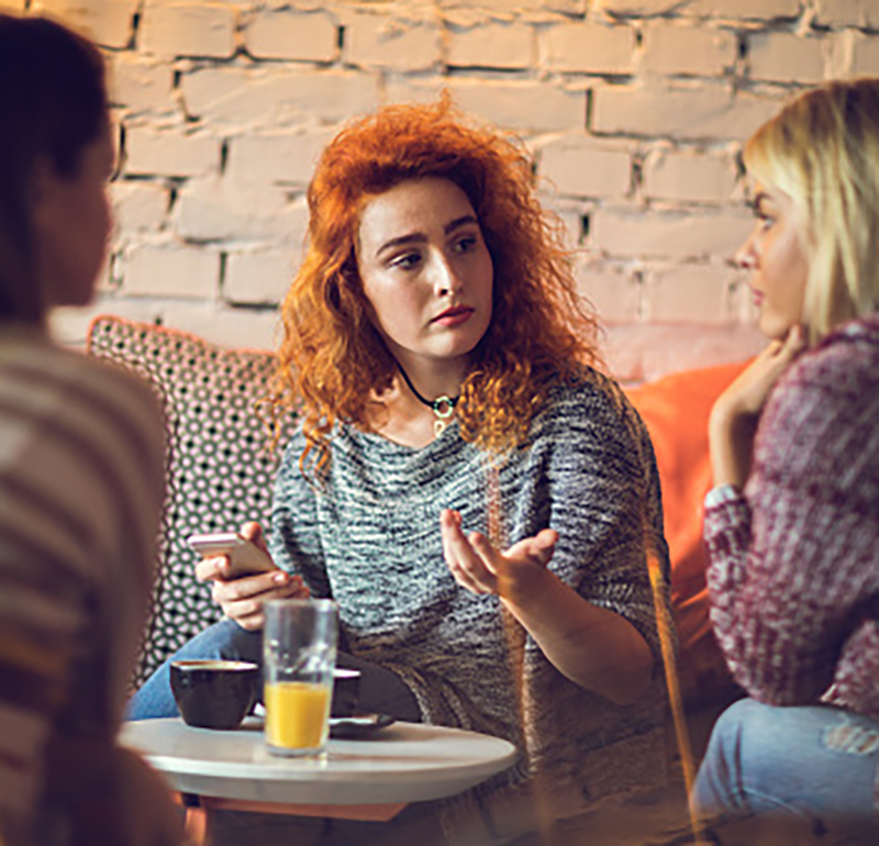 Two young women talking to each other in a café