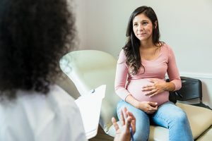 Pregnant woman speaking to doctor