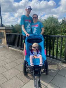 Jack, Hannah and Annabelle in their Epilepsy Action Virtual 10k T-shirts, and Annabelle in her running buggy