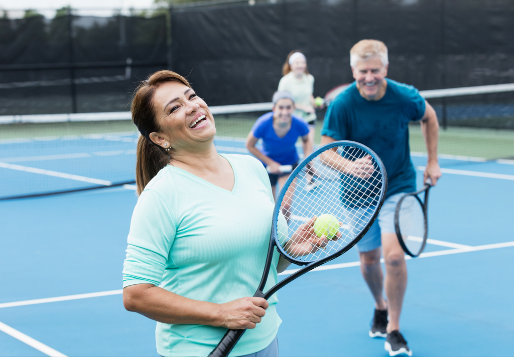 A woman with epilepsy playing tennis with friends