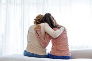 Mother comforting daughter pictured from the back