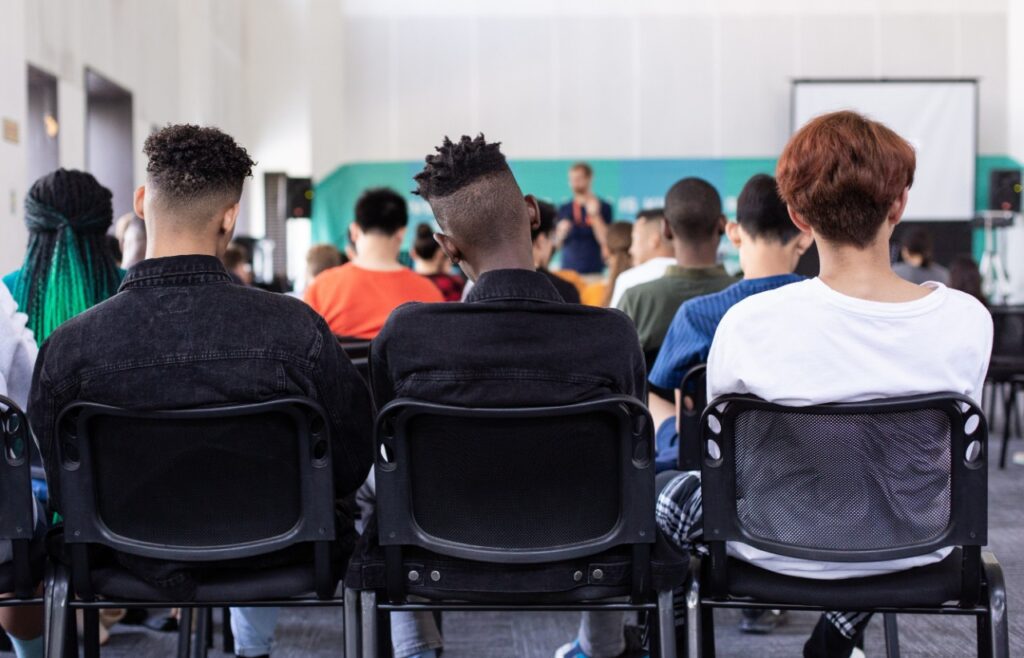 students sitting in a lecture hall or classroom.