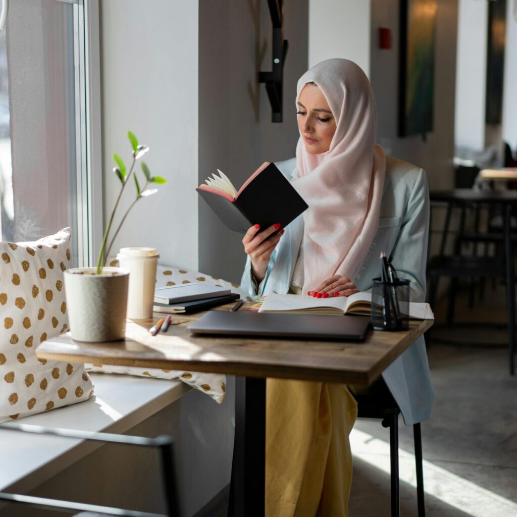 young woman reading a book in a coffee shop