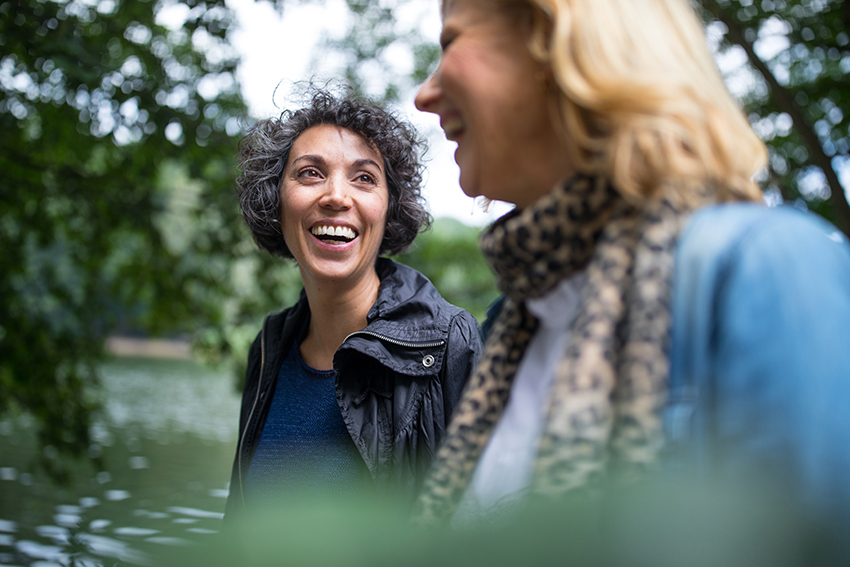 Two people laughing at a park