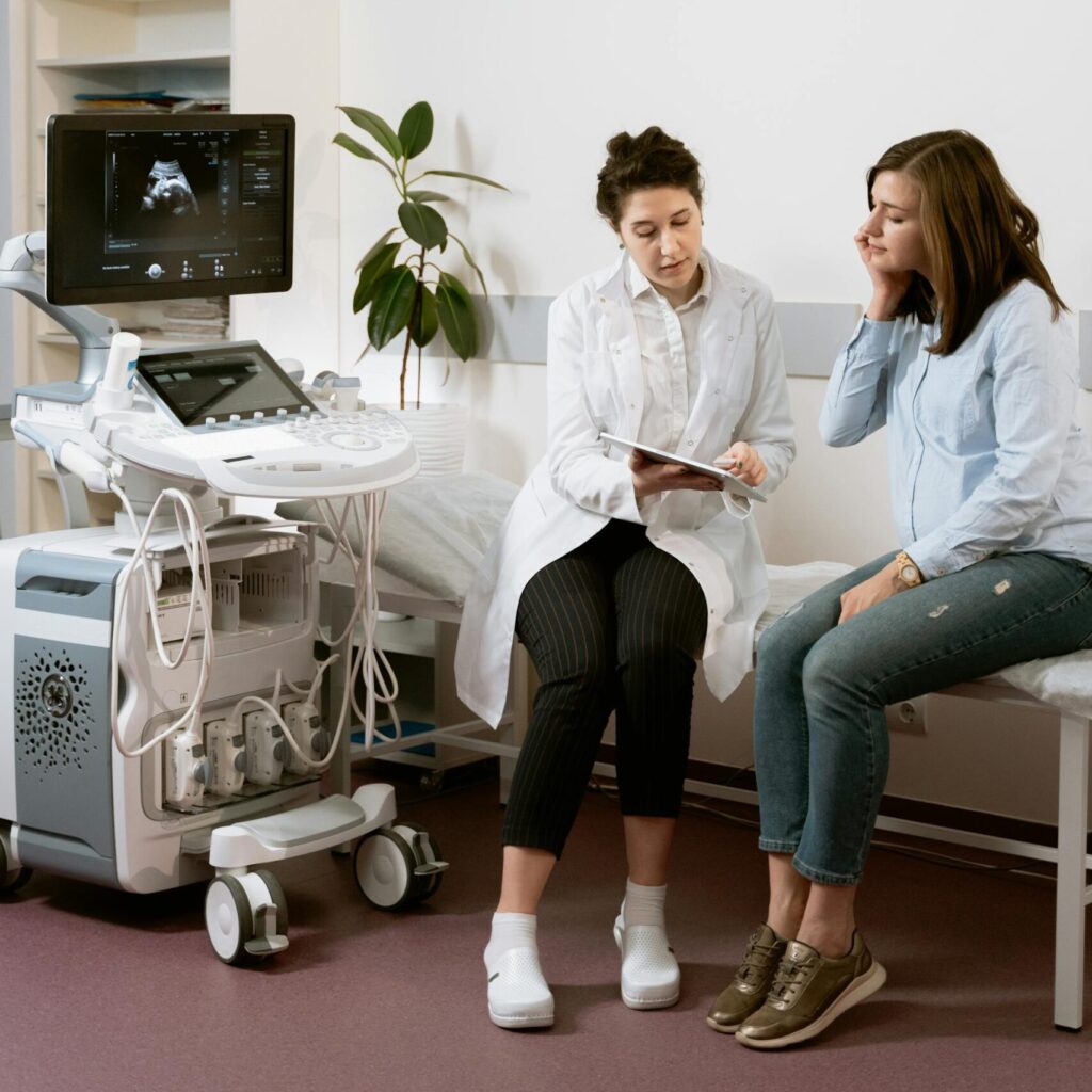 pregnant person in doctor's office with a doctor and ultrasound machine