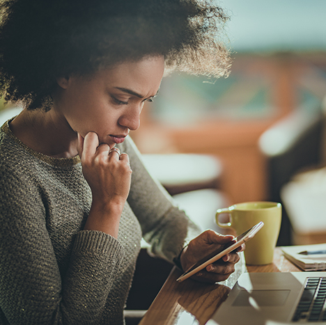 Young woman using phone to send email