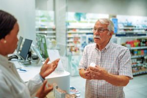 Senior man consulting with female pharmacist about medicine