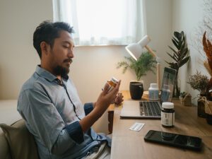 Man looking at label on medication bottle